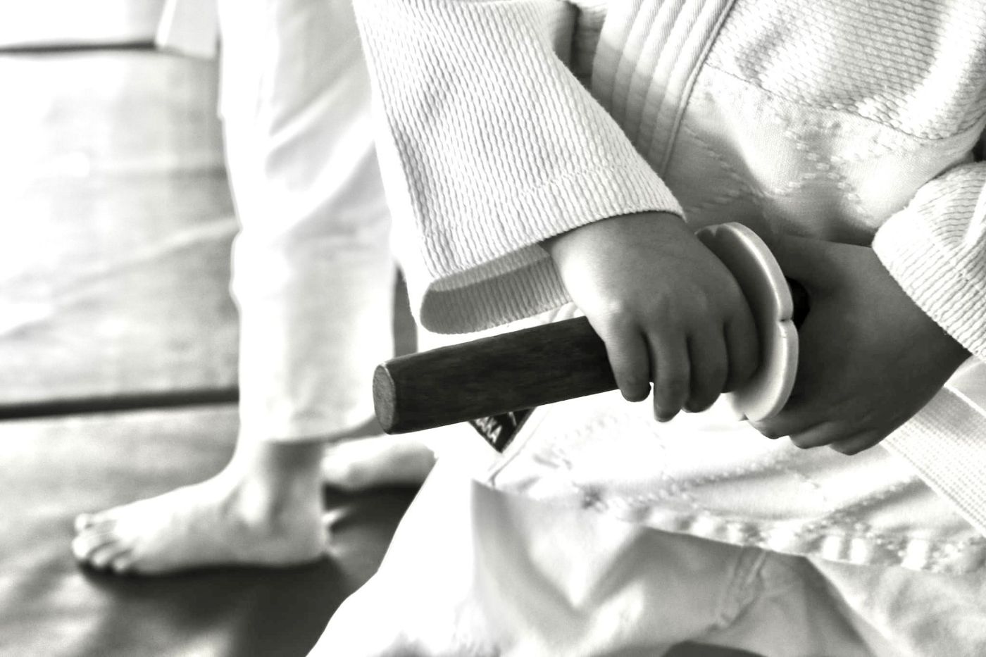 Jeune pratiquant tenant un sabre en bois sur le tatami